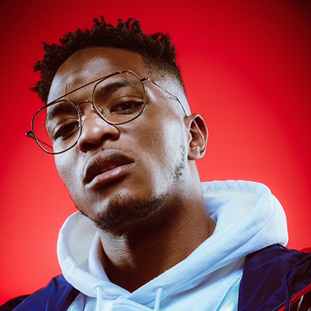 Niska, rappeur français, portrait sur fond rouge